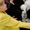 Bundeskanzlerin Angela Merkel auf der Hannover Messe mit dem Roboter "YuMi" am Stand der ABB AG. 
