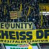Fans von Borussia Dortmund halten ein Plakat in die Luft, um gegen den DFL-Investoren-Deal zu demonstrieren.
