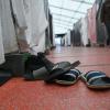 Schuhe einer Flüchtlingsfamilie sind in einem Zelt der Flüchtlingsunterkunft vor einer Wohnparzelle abgestellt.