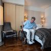 Dominik Peter, Vorsitzender des Berliner Behindertenverbands "Für zeigt in einem barrierefreien Hotelzimmer, wie man von seinem Rollstuhl auf das Bett übersetzen kann.