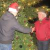 Vereinsringvorsitzender Christian Glöckler gratuliert dem Besitzer des gespendeten Fernseh-Christbaumes in Burlafingen. 