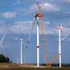 Ein Kran hebt auf der Baustelle eines neuen Windparks in Mecklenburg-Vorpommern ein Rotorblatt für die Montage an das Generatorhaus.