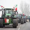 Landwirte fahren mit ihren Traktoren eine Straße an der Mautstelle von Melegnano in der Nähe von Mailand entlang.