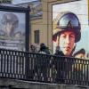 Junge Menschen gehen in St. Petersburg an einer Werbetafel und einem Bildschirm vorbei, die für den Vertragsdienst in der russischen Armee werben.