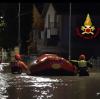 Feuerwehrleute Senigallia schieben ein Schlauchboot durch eine überflutete Straße, um Menschen aus den Häusern zu retten.
