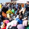 Migranten warten darauf, von der Insel Lampedusa auf das Festland gebracht zu werden.