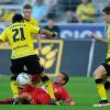 Dortmunds Ilkay Gündogan (l) und Augsburgs Daniel Baier (m) kämpfen um den Ball. "Wir waren komplett chancenlos", räumte FCA-Manager Andreas Rettig anschließend ein.