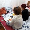 Josefine und Susanne lernen gemeinsam auf dem Bett im Mädchenzimmer und teilen sich dazu den Onlinezugang über ein iPad.