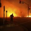 Ein Mann beobachtet das Feuer bei einer Auffahrt zu einer Autobahn in Sylmar, Los Angeles. Seit Donnerstag wütet ein Feuer, dass sich schnell ausbreitet und Dutzende Häuser zerstört hat.