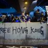 Demonstranten sitzen am Abend auf einer Mauer, die mit einem Graffiti («Free Hong Kong») beschrieben wurde. 