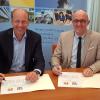 Martin Sailer (links) und Landrat Klaus Metzger unterschreiben die Vereinbarung für mehr Zusammenarbeit im Sozialbereich. 	