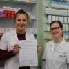 Inga Knie (links) und Denise Krizek (rechts) vom Team der St. Georgs-Apotheke in Nördlingen zeigen die Petition gegen die Arzneimittelknappheit, die in der Apotheke am Tresen ausliegt. 	