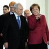 Merkel macht bei Peres-Treffen Druck auf Iran