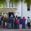 Vor einem Gebäude der Zentralen Ausländerbehörde im brandenburgischen Eisenhüttenstadt warten Asylbewerber auf die Essenausgabe.