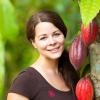 Julia Moser mit Früchten. Ab Januar wird geerntet. Unter der roten Schale befinden sich die köstlichen Kakaobohnen.