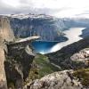 Ein Mann steht an der Spitze des Trolltunga-Felsvorsprungs über dem Ringedalsvatnet See.