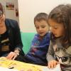 Leiterin Irina Spannagel mit Kindern beim Vorlesen auf dem Lesesofa – Vorlesen und Bücher sind ein wichtiger Baustein im Spracherwerb.