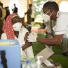 Einer Frau wird in Malawi Impfstoff verabreicht. Bislang hinkt Afrika bei der Verteilung des Impfstoffes massiv hinterher. Das hat Folgen auch für die Entwicklung der Wirtschaft.