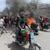 Demonstranten fahren mit ihren Motorrädern an einer brennenden Barrikade vorbei, während sie gegen die Unsicherheit in Port-au-Prince protestieren.