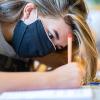 Eine Schülerin sitzt mit einer Mund- und Nasenmaske im Klassenzimmer. In Nordrhein-Westfalen hat die Schule nach den Sommerferien wieder begonnen - mit Maskenpflicht im Unterricht.