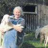 Ein einfaches Leben: Die Schäferin von Haselbach, Verena Pröbstl, mit einem Schaf im Arm und einer Schafherde im Hintergrund. Die 54-Jährige hat 22 Mutterschafe und 22 Lämmer unter ihren Fittichen. 