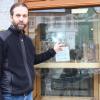 Geschäftsinhaber Andreas Hirn zeigt auf die beschädigten Stellen des Schaufensters seines Ladens in der Wertinger Innenstadt.