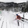 Helfer befreien die Zuschauertribünen in Ruhpolding vom Schnee.