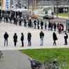 Menschen stehen in einer Warteschlange vor einem Impfbus in Salzburg. Die Corona-Lage in der Region ist dramatisch. Die Kliniken bereiten sich auf Triage vor.