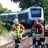 Rettungskräfte der Feuerwehr gehen vor dem verunglückten Zug auf dem Bahngleis bei Isenbüttel.