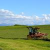 Ein Landwirt wendet in der Nähe von Issing in Oberbayern das Heu auf seinem Feld.