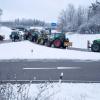 Zu Beginn der Protestwoche startet ein Traktoren -und LKW-Konvoi nach München. Etliche Landwirte und Spediteure blockieren mit ihren Fahrzeugen die beiden Kreisverkehre an der A96.