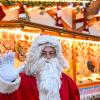 Ein Weihnachtsmann winkt bei der Eröffnung des Weihnachtsmarkts in Potsdam.