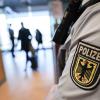 Ein Beamter der Bundespolizei kontrolliert Reisende am Flughafen.