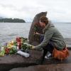 Eine Jugendliche legt am See vor der Insel Utøya Blumen für die Opfer nieder. dpa