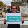 Kurt Späth demonstriert neben dem Rathaus gegen das Erscheinungsbild des Klimacamps in Augsburg.