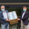 Roland Stark (links), Inhaber der Wehringer Firma Winsport, übergab den ersten Karton mit MSN-Masken persönlich an Klinikvorstand Martin Gösele.  	
