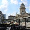 Ein Paar aus Nordrhein-Westfalen sitzt im leeren Sightseeing-Bus. Im Hintergrund ist der Deutsche Dom zu sehen.  	