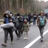 Migranten auf dem Weg zur Notunterkunft an der Grenze zu Polen.