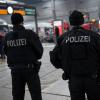 Polizisten stehen im Münchner Hauptbahnhof. Die Fahndung nach den Verdächtigen dauert an.