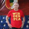 „WIR DER FCA“ ist das neue Motto des Bundesligisten. Manager Stefan Reuter trug das T-Shirt bei der Trikot-Präsentation am Donnerstag. 	