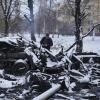 Ukraine, Charkiw: Ein Mann fotografiert noch schwelende zerstörte russische Militärfahrzeuge am Stadtrand. 