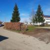 Das Bild zeigt links die beengte Kinderheimstraße mit parkenden Autos und der Buchenhecke, die weichen muss. An der Stelle wird ein Streifen für sechs Parkplätze geschaffen.