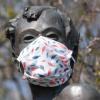 Eine selbstgebastelte Mundschutzmaske über der Kästner-Bronzeplastik in Dresden. Ingenieuren zufolge haben Staubsaugerbeutel für eine Maske der Marke Eigenbau hervorragende Filtereigenschaften.