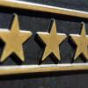 Ein Messingschild mit den Sternen des Deutschen Hotel- und Gaststättenverbandes hängt an der Fassade eines Hotels.