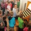 Dicht umringt: Organist Martin Geßner führte den Kindern die Funktionsweise der Roggenburger Orgel vor. 	<b>Foto: Stefan Kümmritz</b>
