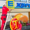 Das T weicht dem E: Arbeiter tauschen das alte Tengelmann-Schild gegen das Edeka-Xpress-Logo aus. Die neuen Xpress-Läden sind sozusagen Edeka-Filialen im Kleinformat.  	