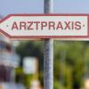 Ein Schild «Arztpraxis» steht an der Straße.