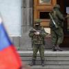 Bewaffnete und russische Flaggen vor einem Regierungsgebäude auf der Krim.