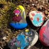 So sehen ein paar der bunten Steine aus: Mit Filzstiften oder Acrylfarben lassen sich lustige Motive auf den grauen Stein malen.  	
