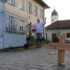 Pfarrer Rüdiger Lange steht vor dem Haus, das für ihn und seine Frau ausschlaggebend war, nach Kleinsorheim zu kommen. Im Hintergrund ist die Kirche des Ortes zu sehen. Das Holzkreuz hat Lange selbst gebastelt.  	